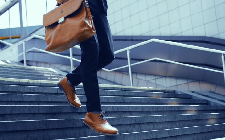 close up image of a business man walking down stairs