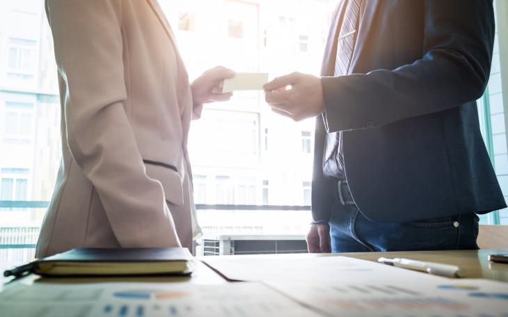 close up image of two people exchanging a note