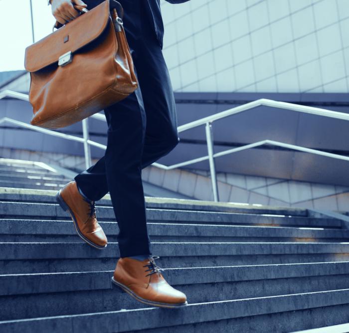 close up image of a business man walking down stairs
